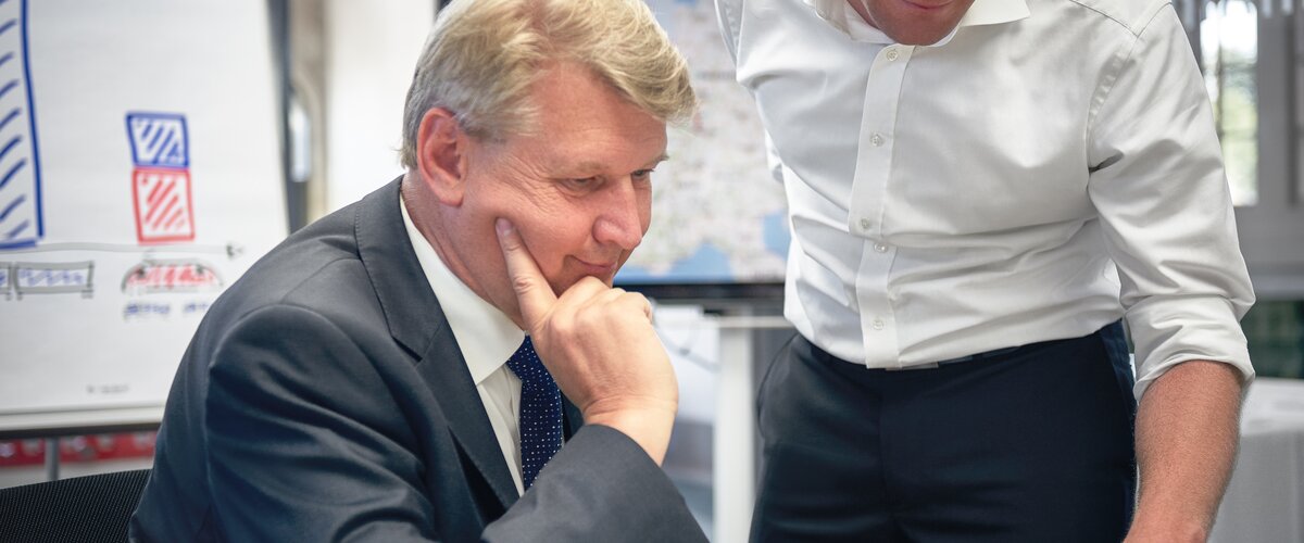 Zwei Männer im Büro schauen interessiert auf einen Bildschirm.  | © DB AG / Faruk Hosseini