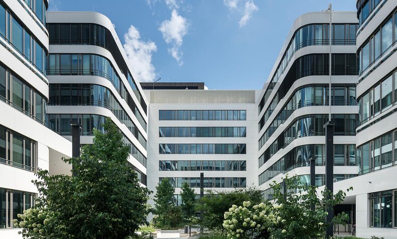 Ein modernes, weißes Gebäude mit einem Innenhof mit vielen Pflanzen