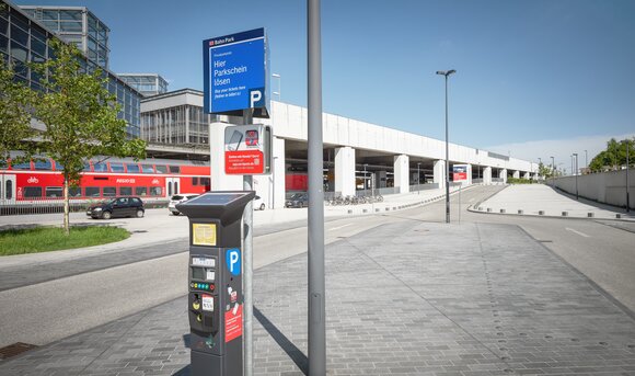 Ein solarbetriebener Parkscheinautomat vor einem Bahnhof der Deutschen Bahn.