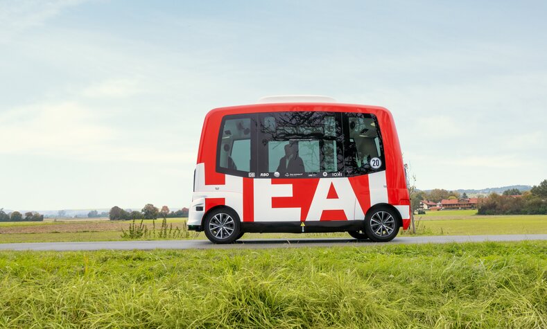 An electric shuttle drives down a street.