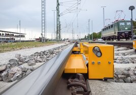 Eine  Schienenschmiereinrichtungen ist im Gleisbett montiert und reduziert das Quietschen der Züge in Kurven.