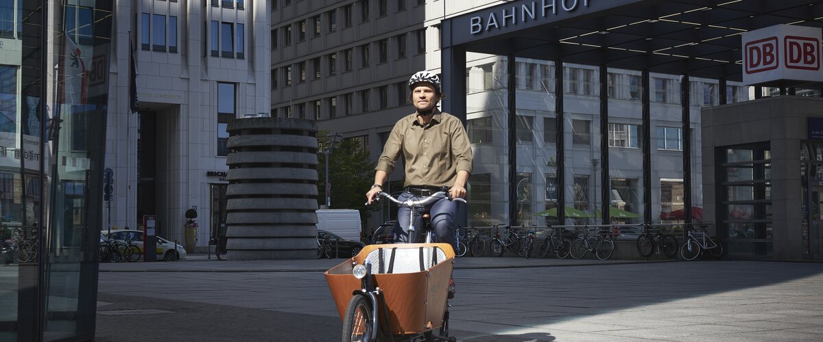 Ein Mitarbeiter fährt mit dem DB-Firmenrad über den Potsdamer Platz zur Arbeit. | © DB AG / Faruk Hosseini