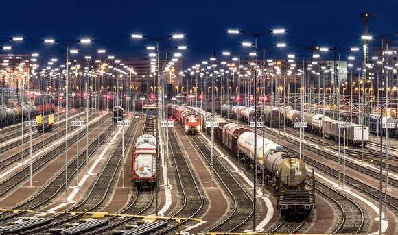 Eine Gleisanlage wird bei Nacht mit LED-Technik beleuchtet.