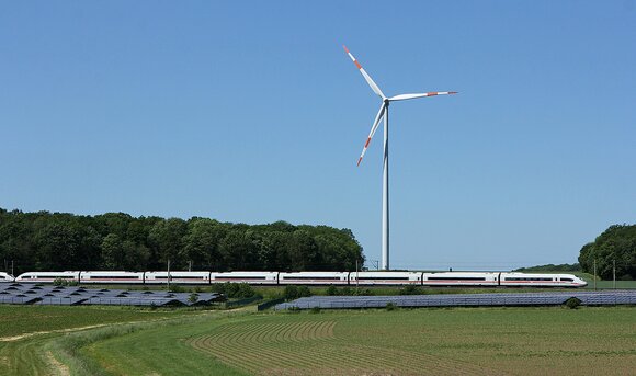 ICE passiert Solarpark und Windrad