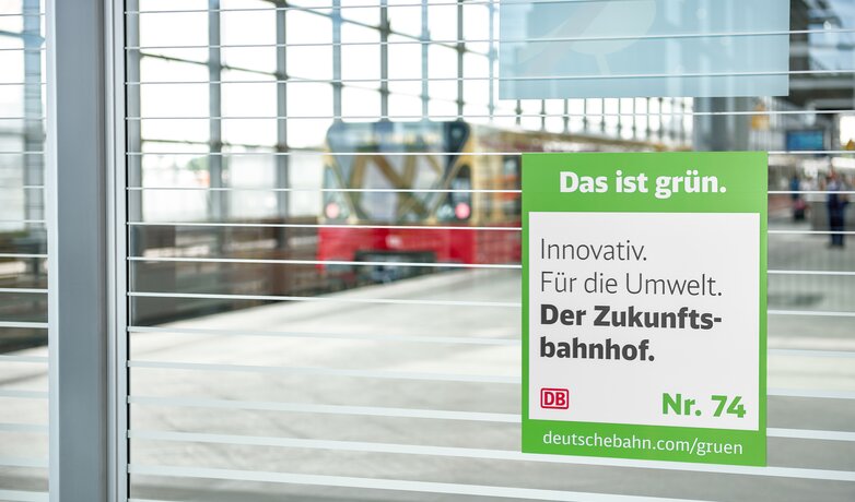 Am Bahnhof Südkreuz hängt das Signet für die Maßnahme Zukunftsbahnhof mit der Botschaft "Innovativ. Für die Umwelt. Der Zukunftsbahnhof.". | © DB AG / Faruk Hosseini