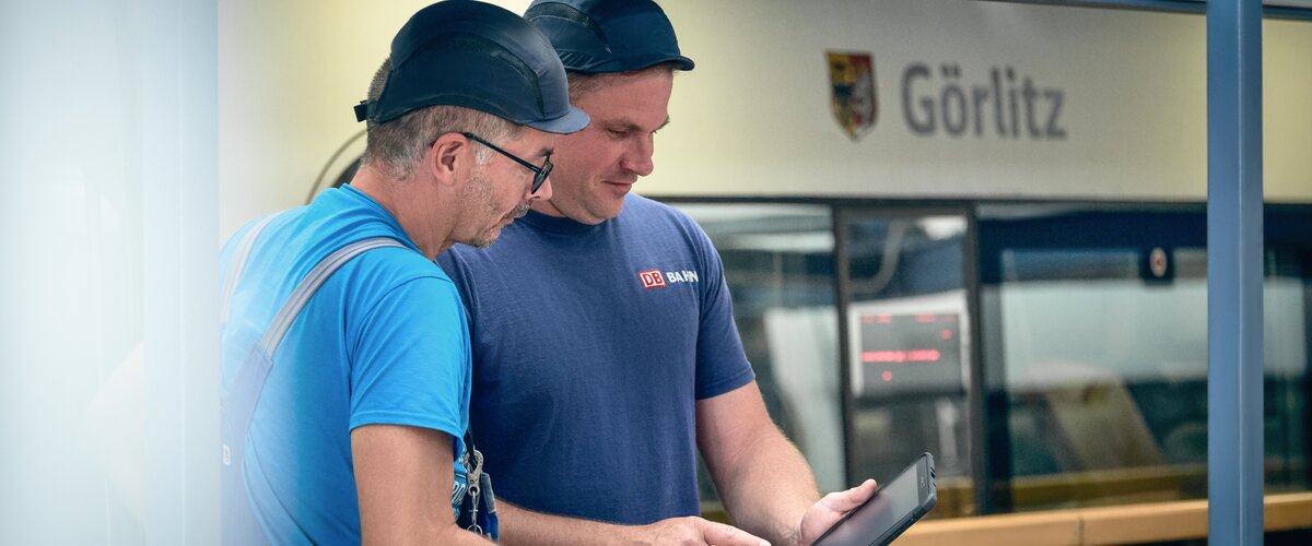 Zwei Mitarbeiter arbeiten am Bahnhof mit einem Tablet. | © DB AG / Faruk Hosseini