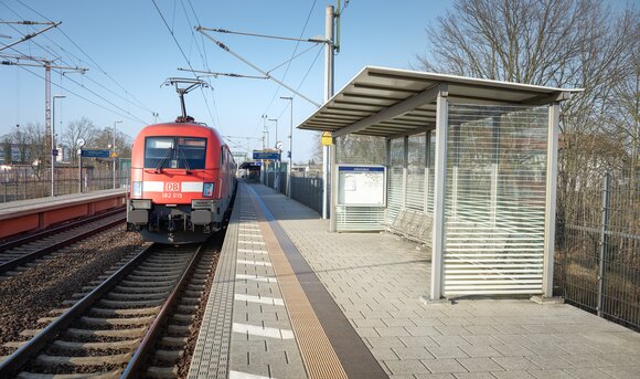 Ein Zug hält an einer Bahnstation. 