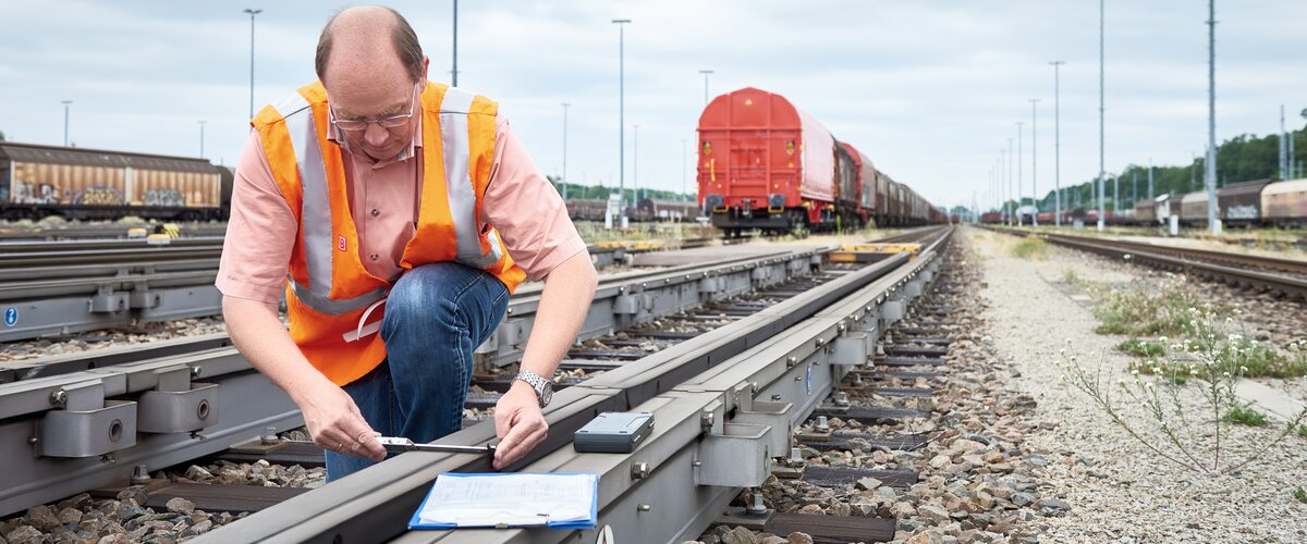 Ein Mitarbeiter prüft die Bremsen direkt an der Schiene.  | © DB AG / Faruk Hosseini