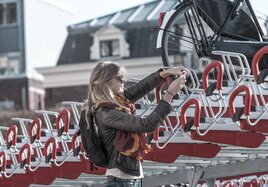 Eine Frau nutzt die Möglichkeit des neuen Fahrradparkers.