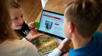 Eine Familie durchstöbert auf dem Tablet die BahnBonus Prämienwelt nach den nachhaltigen Produkten und Dienstleistungen. | © DB AG / Faruk Hosseini