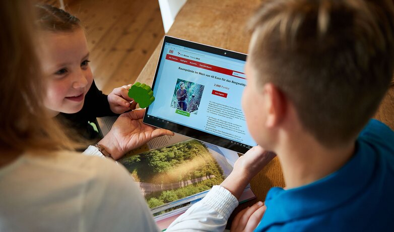 Eine Familie durchstöbert auf dem Tablet die BahnBonus Prämienwelt nach den nachhaltigen Produkten und Dienstleistungen. | © DB AG / Faruk Hosseini