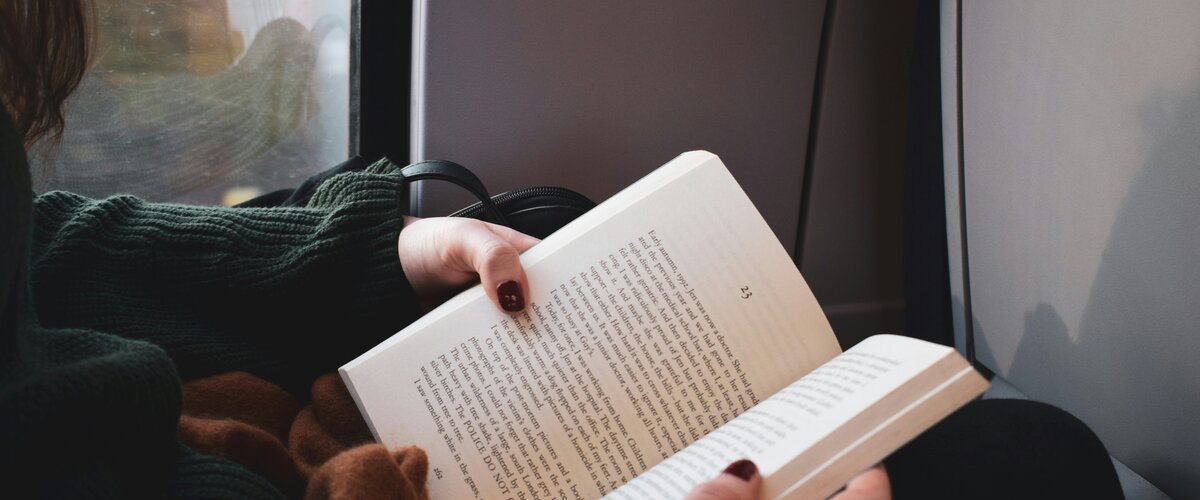 Eine Reisende im Zug liest ein Buch. | © Will Tarpey auf Unsplash