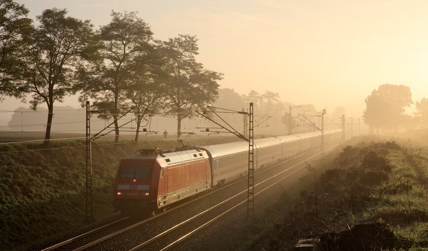 Ein IC rollt im Morgennebel durch die Landschaft.