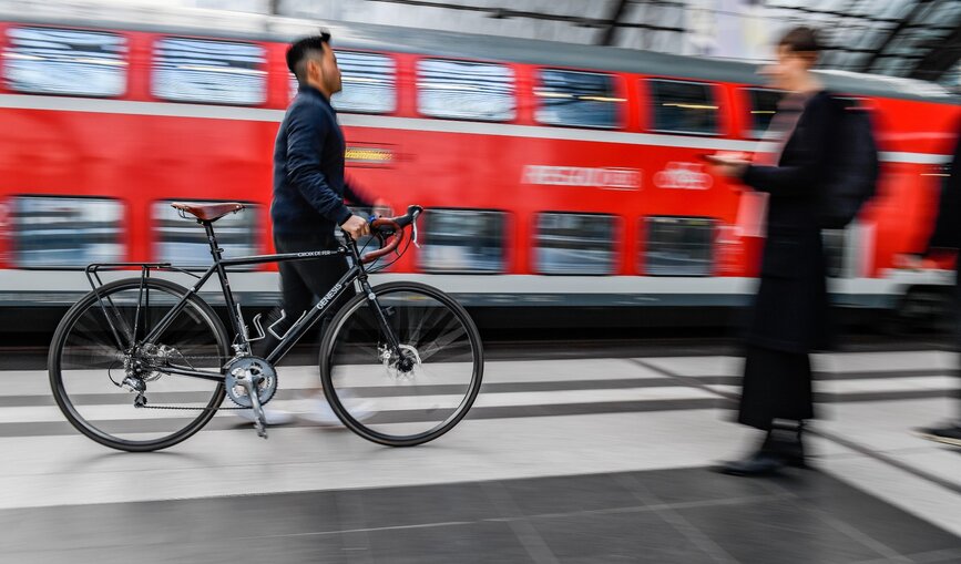 Ein Mann schiebt sein Fahrrad über den Bahnsteig im Berliner Hauptbahnhof.