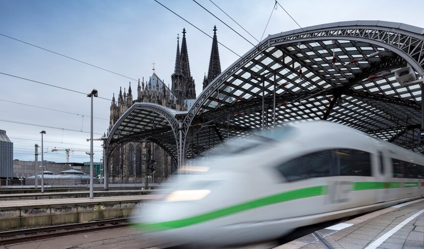 Ein grüner ICE bei der Ausfahrt aus dem Hauptbahnhof Köln.