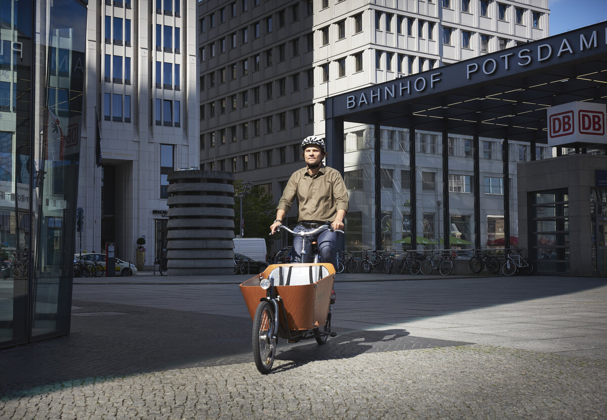 Ein Mitarbeiter fährt mit dem DB-Firmenrad über den Potsdamer Platz zur Arbeit. | © DB AG / Faruk Hosseini