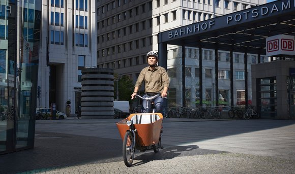 Ein Mitarbeiter fährt mit dem DB-Firmenrad über den Potsdamer Platz zur Arbeit.
