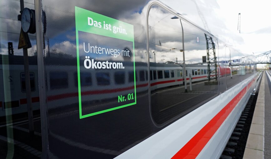 Ein ICE-Zug von der Seite mit dem Das ist grün.-Signet "Unterwegs mit Ökostrom".