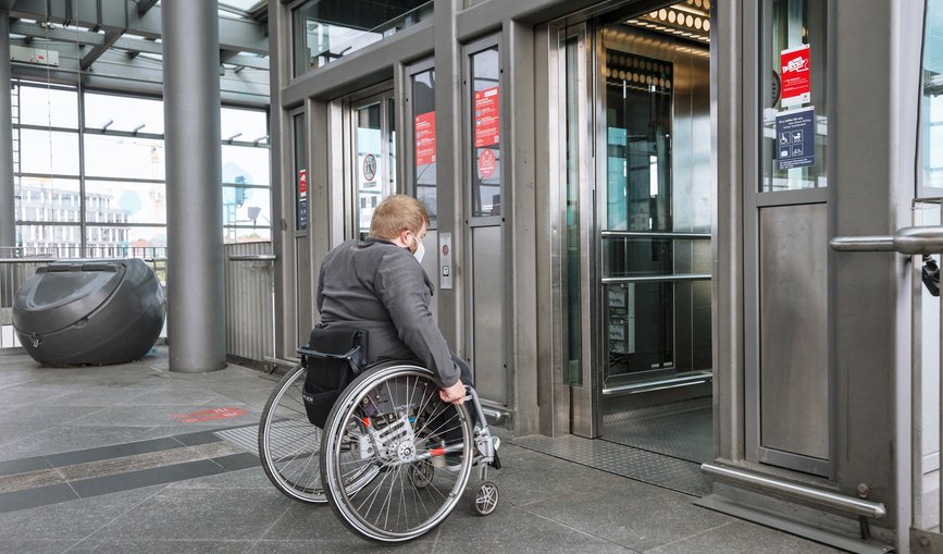 Reisender im Rollstuhl nutzt einen Aufzug auf einem barrierefreien Bahnhofsgleis (Berlin Südkreuz)
