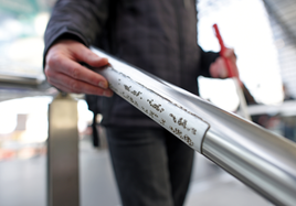 Mann greift nach Geländer mit Taktiles Leitsystem in Berlin