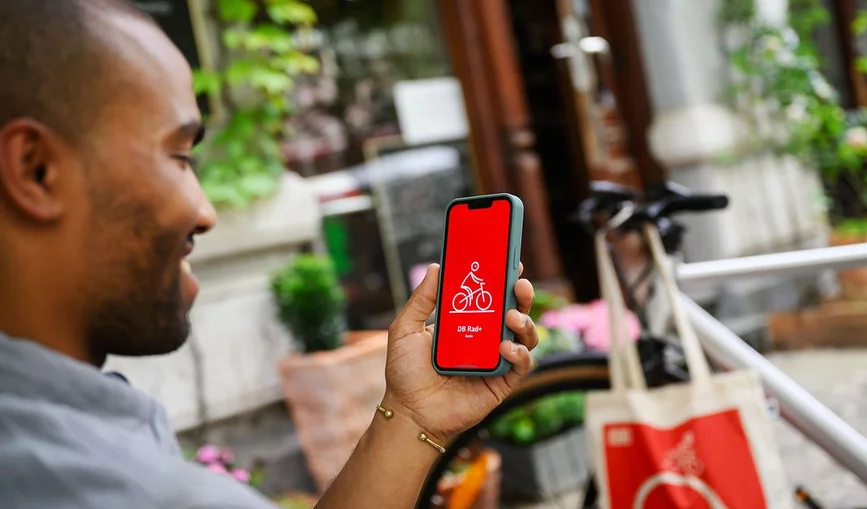 Ein Mann nutzt die App DB Rad+ auf seinem Handy.