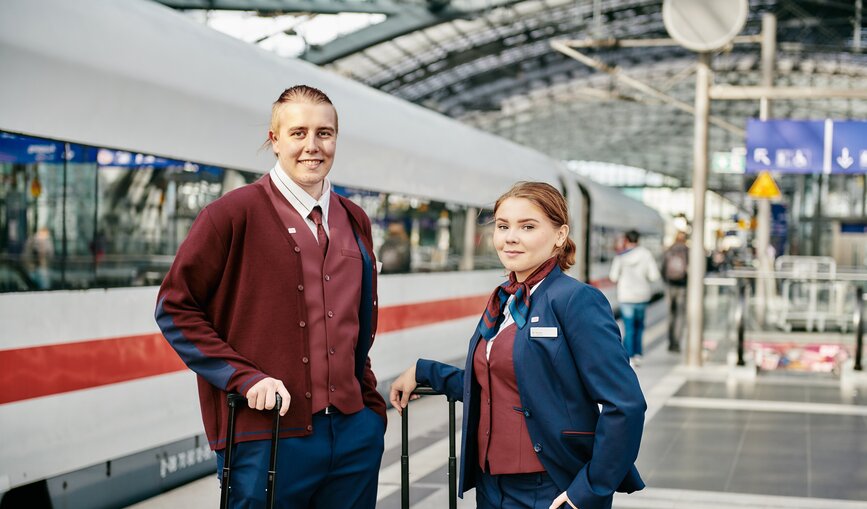 Zwei junge Mitarbeitende am Bahnhof