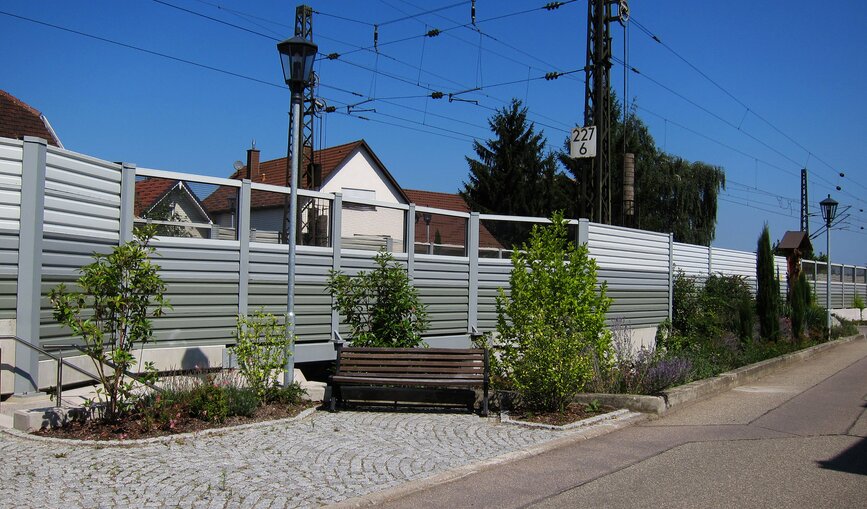 Eine begrünte Lärmschutzwand mit Sitzgelegenheit