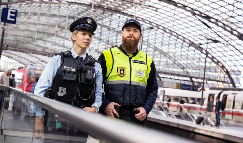 Eine Bundespolizistin und ein Mitarbeitender von DB Sicherheit stehen an einem Gleis am Berliner Hauptbahnhof. | © Deutsche Bahn AG / Max Lautenschläger