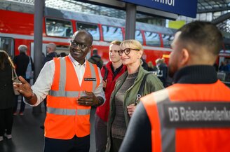 Ein Mitarbeitender der DB Sicherheit erklärt Reisenden den Weg | © DB AG/ Max Lautenschläger