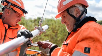 Zwei Mitarbeiter bei Oberleitungsarbeiten. | © Deutsche Bahn AG / Max Lautenschläger