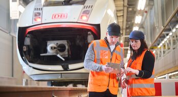 Mitarbeiter:innen im ICE Werk Cottbus mit Tablet Computer | © DB AG/ Annette Riedl