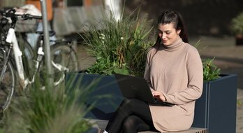 Eine Frau sitzt auf einer Parkbank. | © DB AG/ Oliver Lang