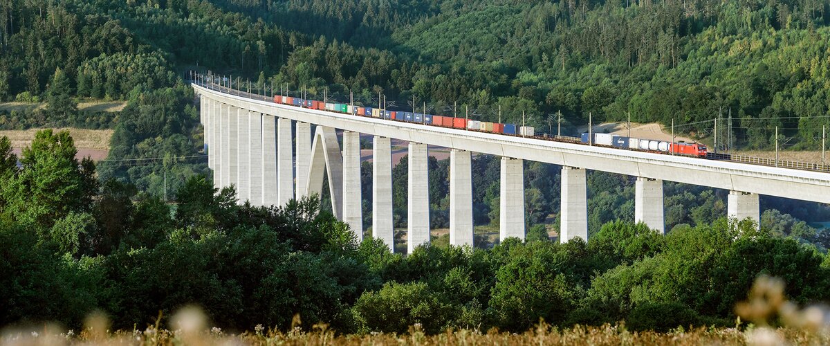 Ein Güterzug fährt über eine Brücke. | © DB AG / Oliver Lang