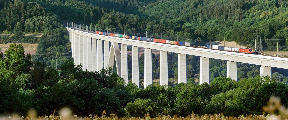 Ein Güterzug fährt über eine Brücke. | © DB AG / Oliver Lang