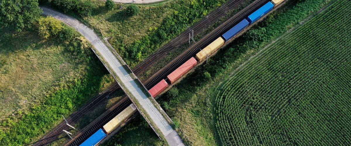 Ein Güterzug unterfährt eine Brücke. | © DB AG / Oliver Lang