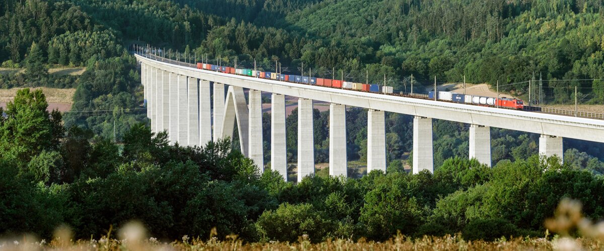 Ein Güterzug fährt über eine Brücke. | © DB AG / Oliver Lang