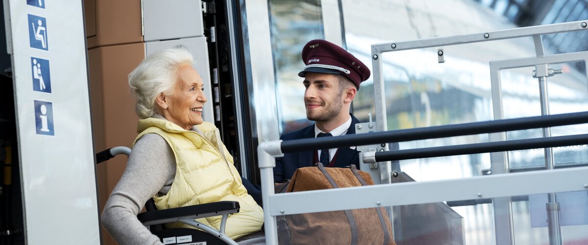 Ein DB Mitarbeiter hilft einer Rollstuhlfahrerin beim Ausstieg aus einem ICE. | © Deutsche Bahn AG / Max Lautenschläger