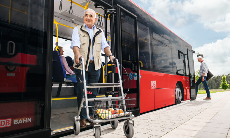 Ein älterer Herr steigt mit seinem Rollator aus einem niederflurigen Bus.