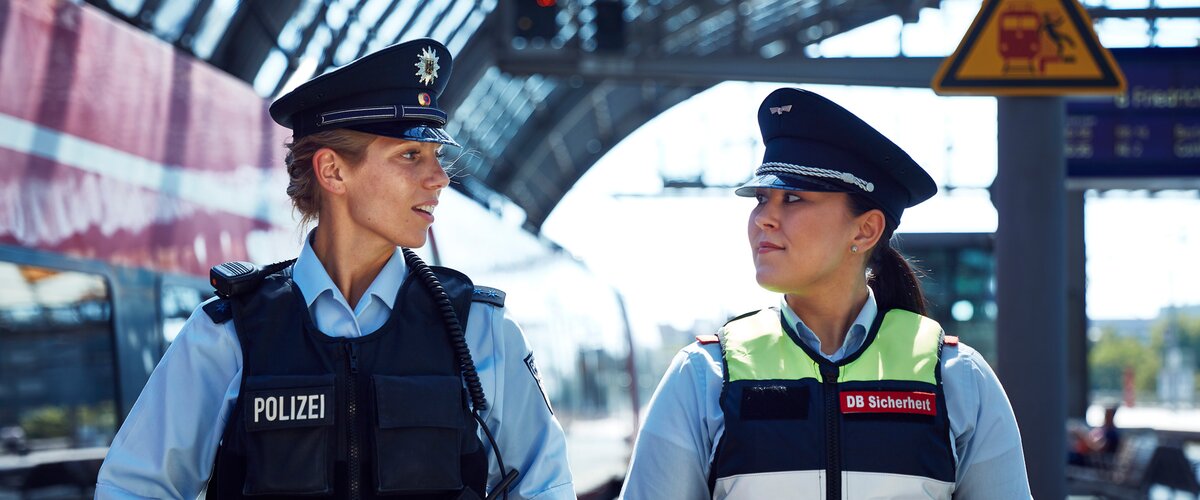 Zwei Mitarbeitende von Polizei und DB Sicherheit an einem Bahngleis | © DB AG / Björn Ewers