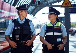 Zwei Mitarbeitende von Polizei und DB Sicherheit an einem Bahngleis
