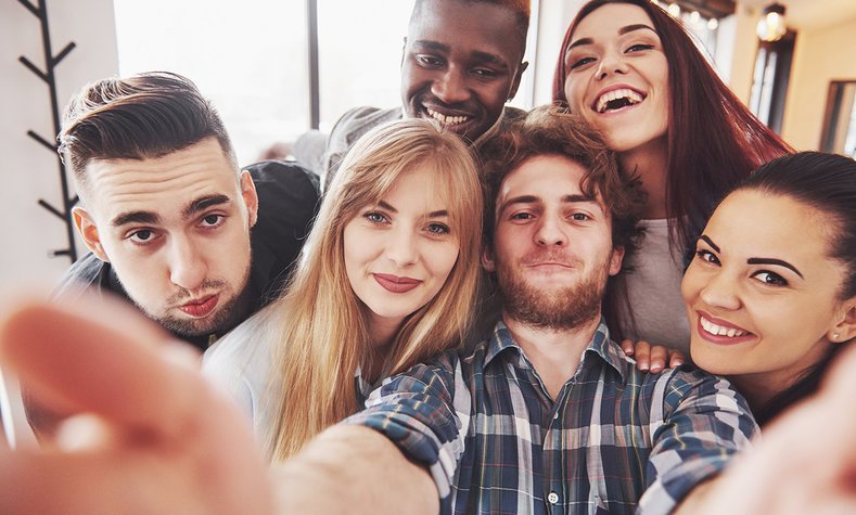 Eine Gruppe junger Menschen macht ein Selfie von sich.