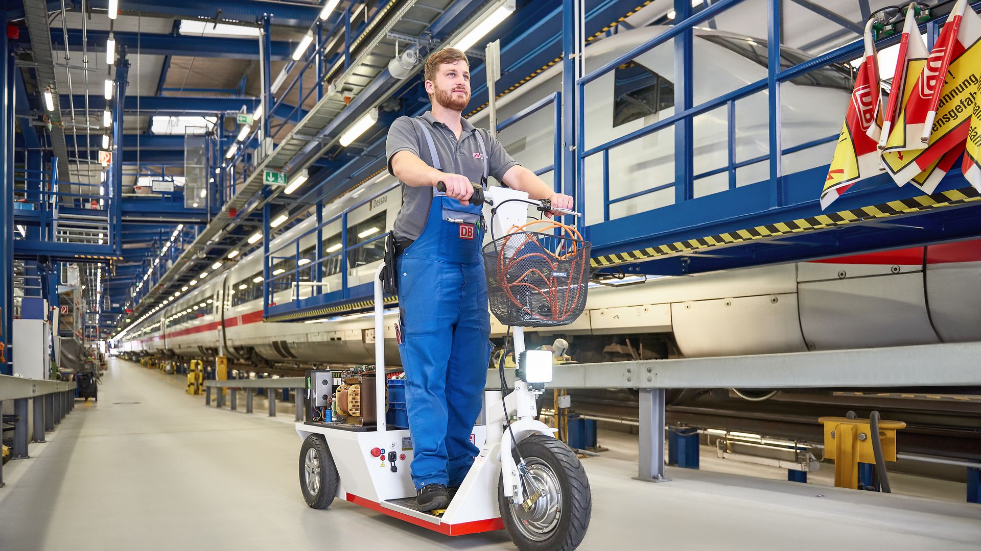 Ein Mitarbeiter ist mit einem E-Scooter im Werk unterwegs. 