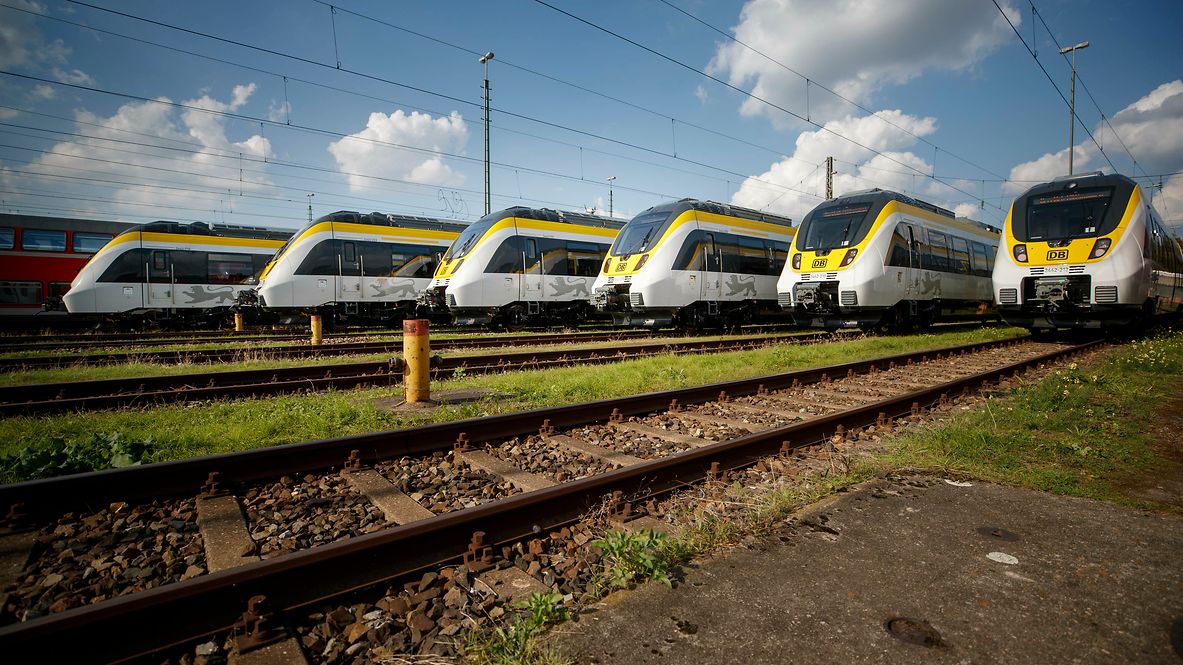 Sechs gelbe-weiße Regionalzüge stehen versetzt nebeneinander am Bahnhof