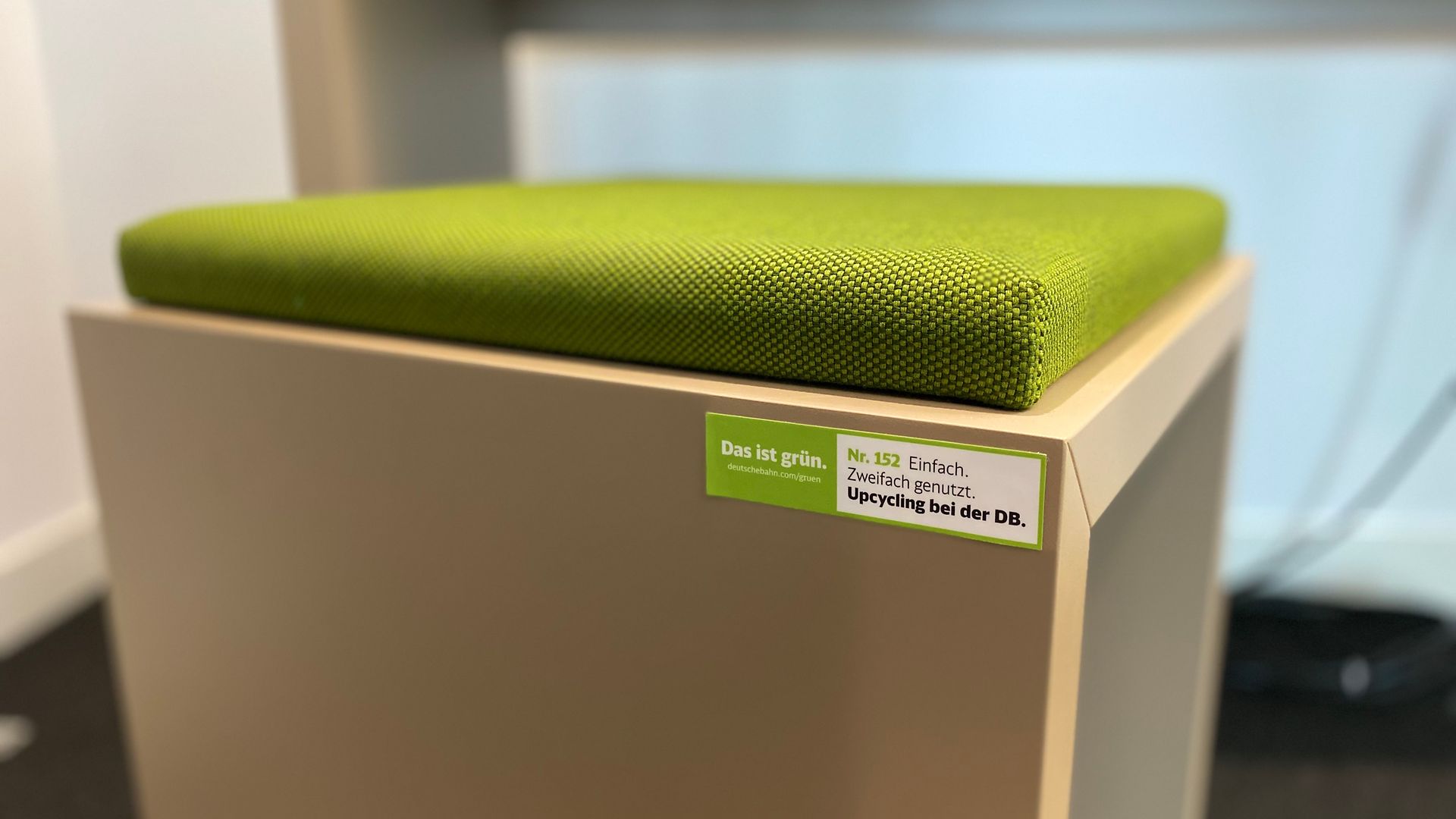 Ein Sitzhocker mit grünem Polster und Das ist grün.- Label