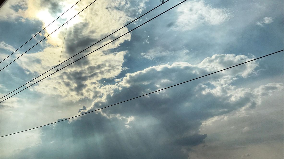 Blick von unten auf eine Oberleitung und in den Himmel