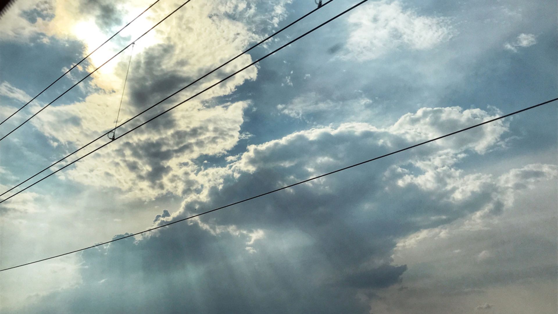 Blick von unten auf eine Oberleitung und in den Himmel