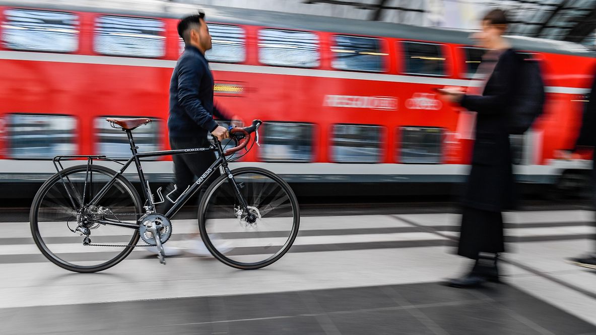 Ein Mann schiebt sein Fahrrad über den Bahnsteig im Berliner Hauptbahnhof.