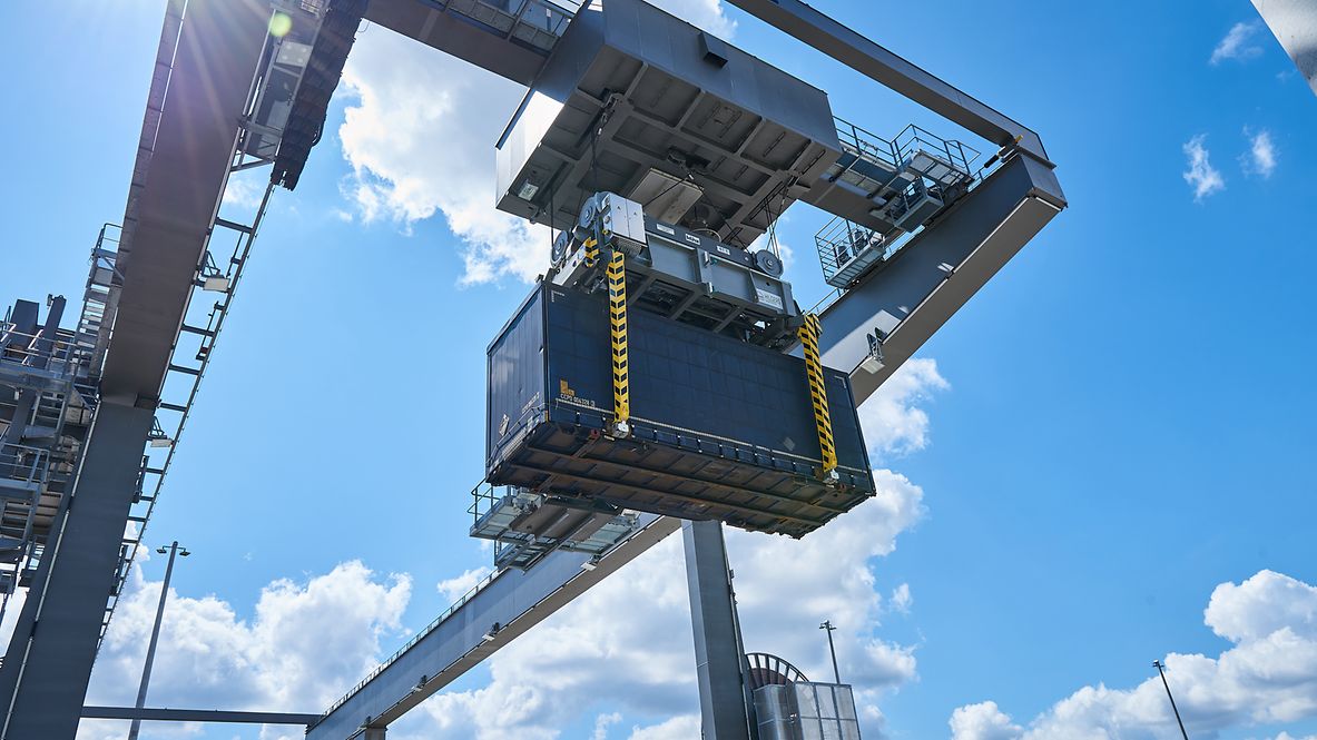 Gütercontainer werden mit einem Kran verladen.