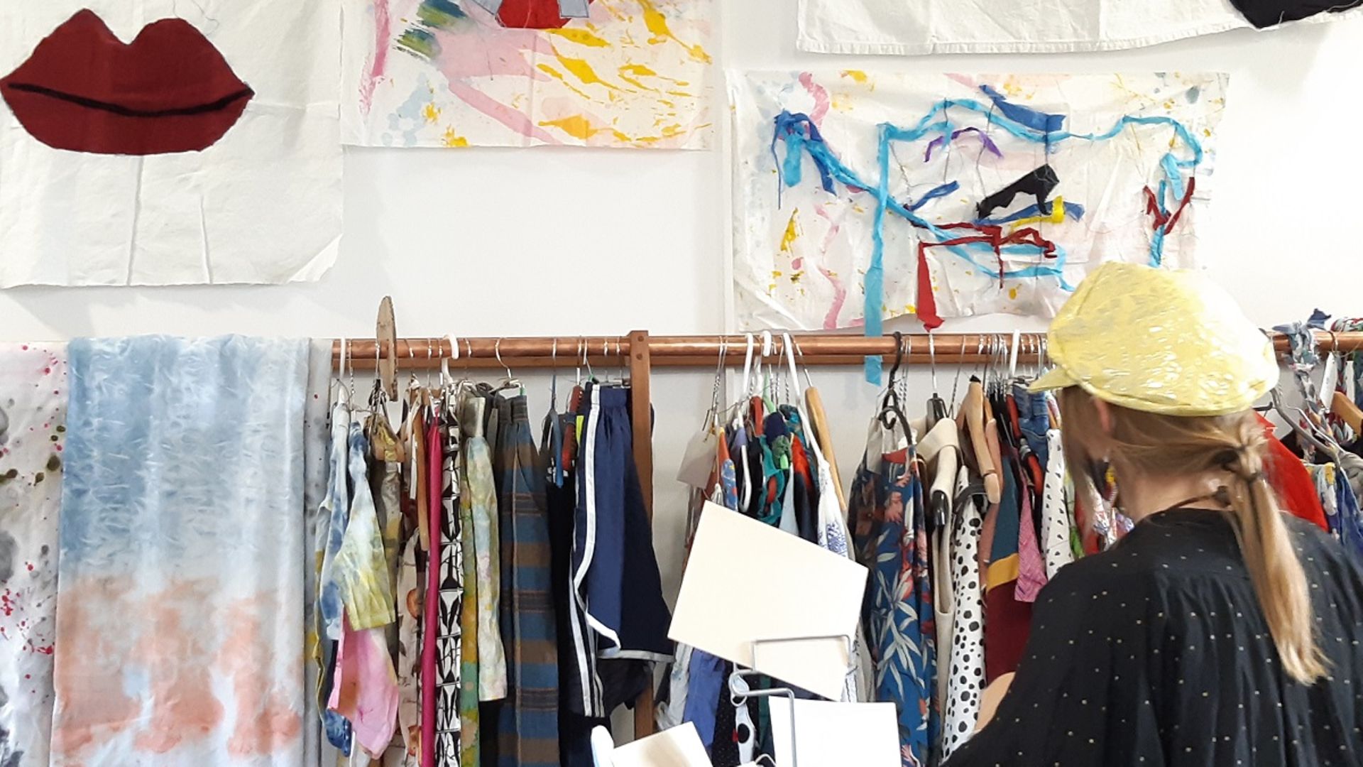 Frau steht vor einer Kleiderstange im Tauschladen