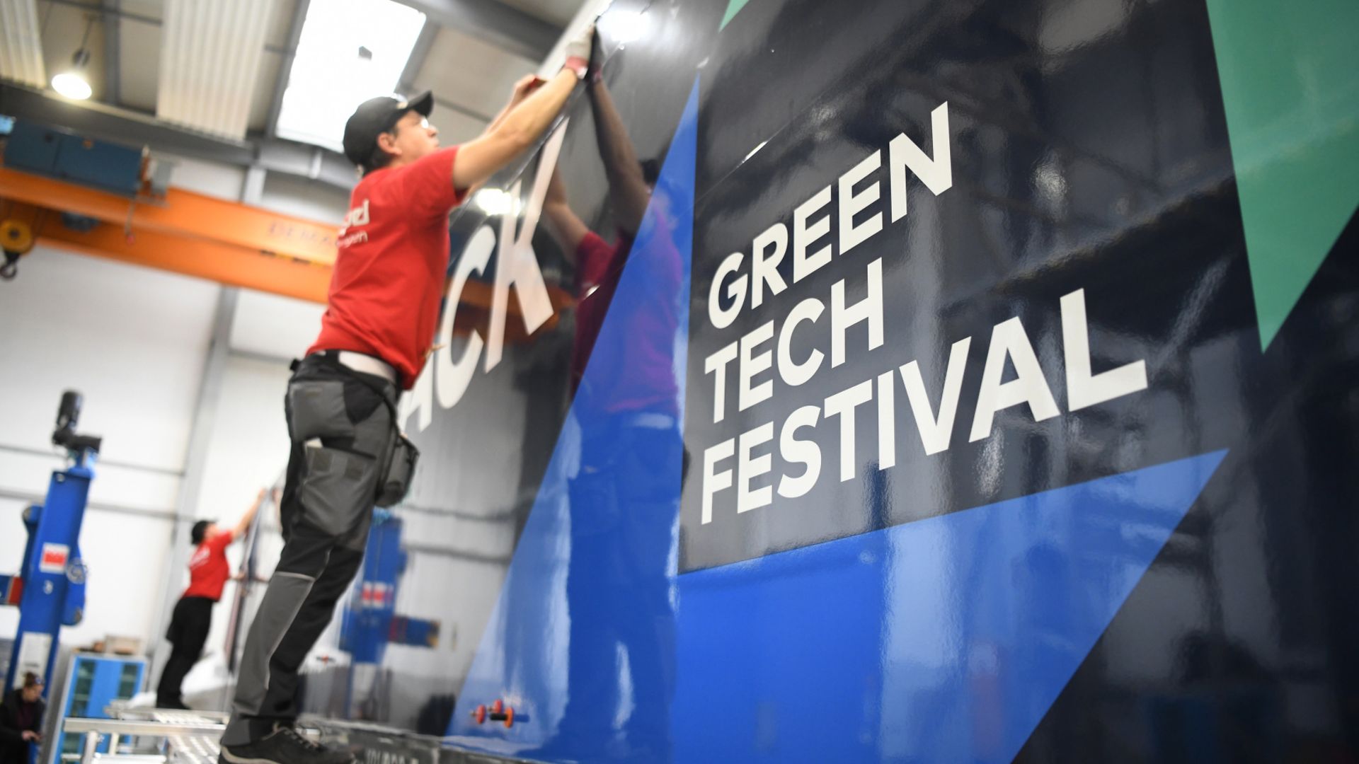 Ein Zug wird mit Werbung für das GREENTECH FESTIVAL beklebt.